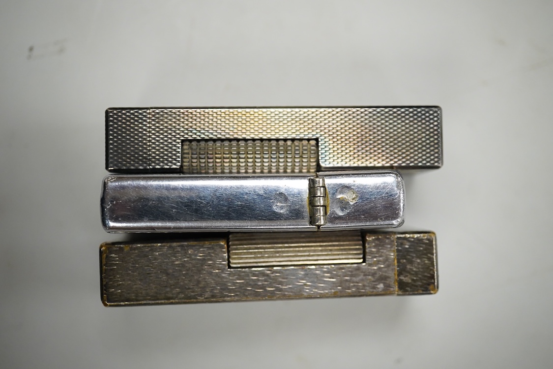 Two Dunhill rollagas silver plated lighters, barley pattern and rusticated 6.5cm long and a U.S.S. Coronado LPD-11, zippo lighter (3)